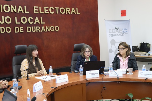 tres mujeres sentadas frente a mesa con micrófonos
