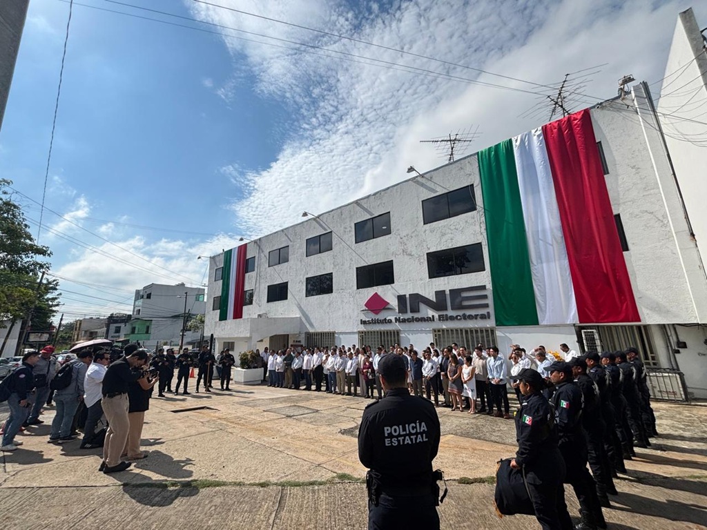 edificio de tres pisos con bandera de México, verde, blanco y rojo