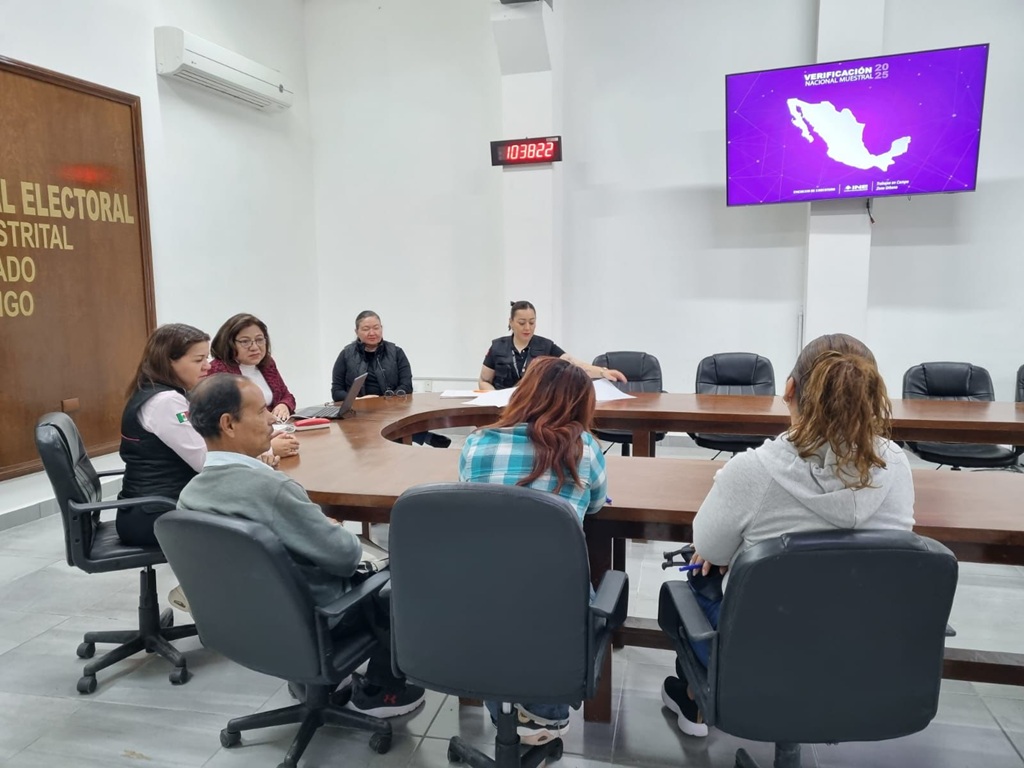 seis personas sentadas alrededor de una mesa ovalada de madera